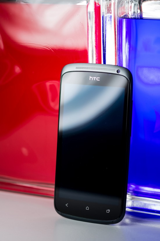 La façade du HTC One S, toute de verre vêtue, présentant l'écran, les touches capacitives, l'écouteur ainsi que la caméra secondaire.