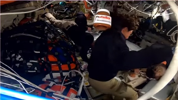 Un pot de Nutella en apesanteur dans le vaisseau Integrity passe derrière l'astronaute Christina Koch.