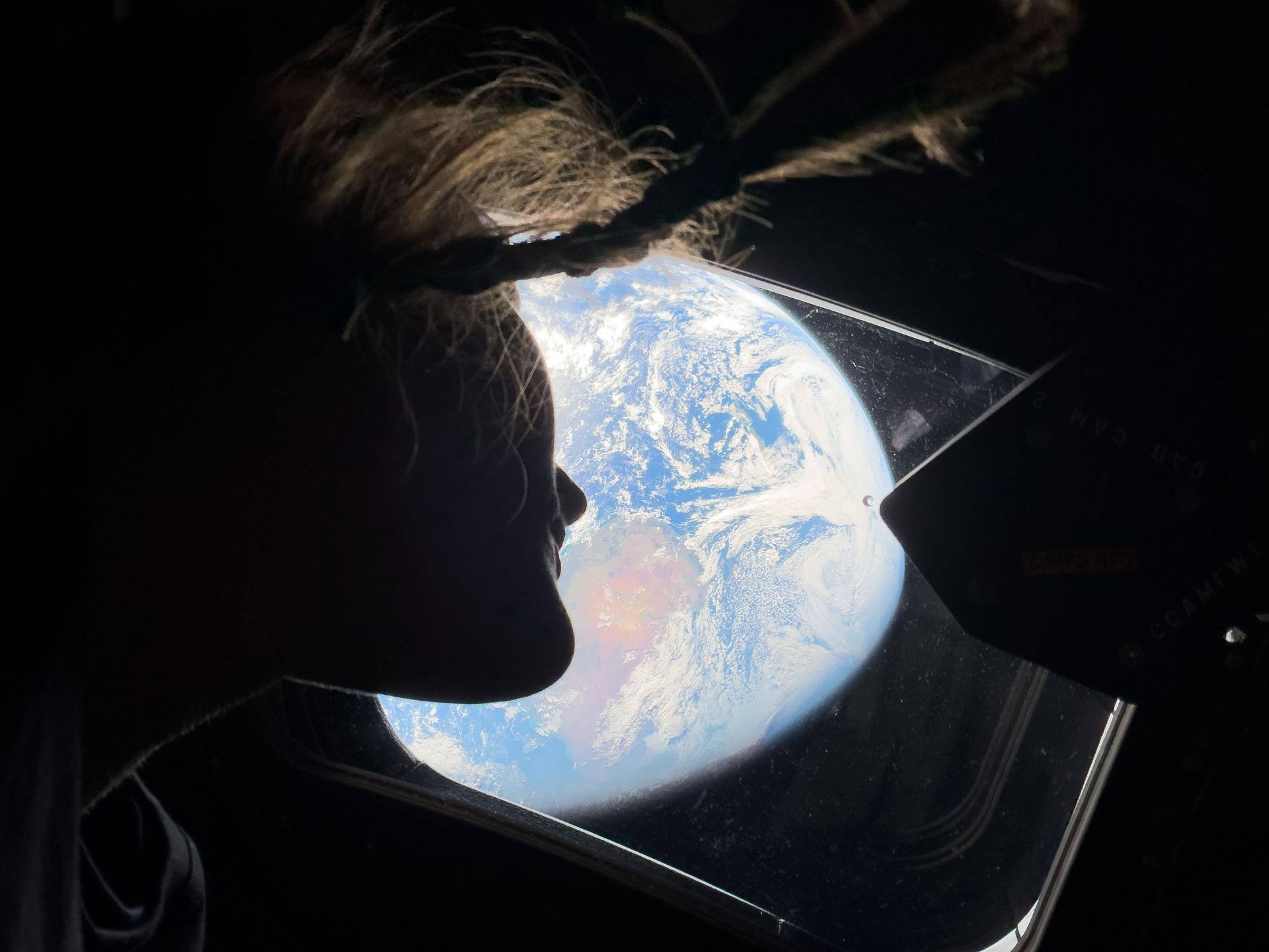 L'astronaute Christina Koch jette un regard sur la Terre à travers l'une des fenêtres du vaisseau Orion lors de la mission Artemis II.